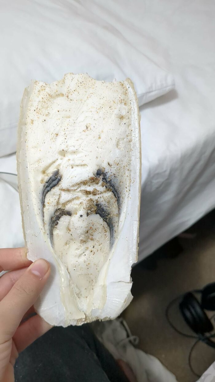 Close-up of a strange pic showing the inside of a worn shoe sole with an unusual pattern and dirt marks.