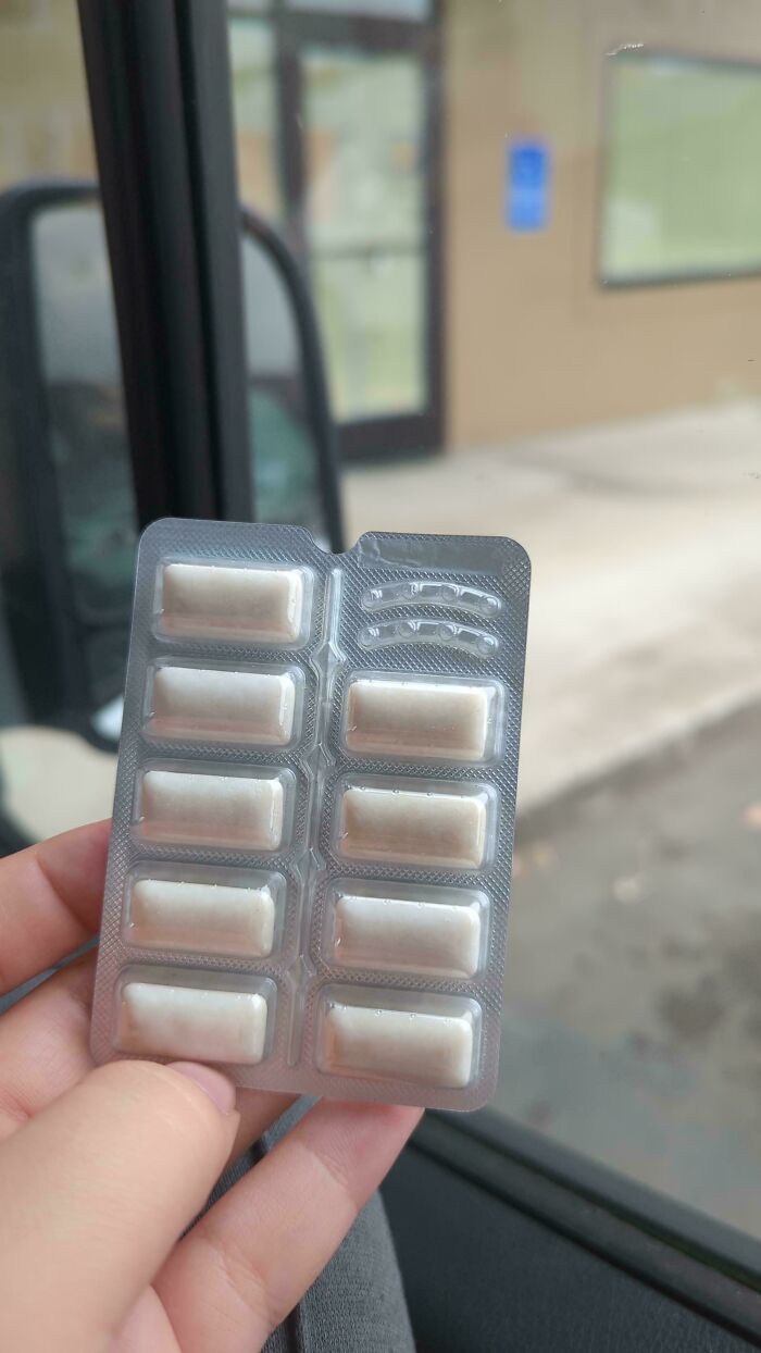 Hand holding a pack of rectangular gum pieces, illustrating obvious shrinkflation in everyday products in America.