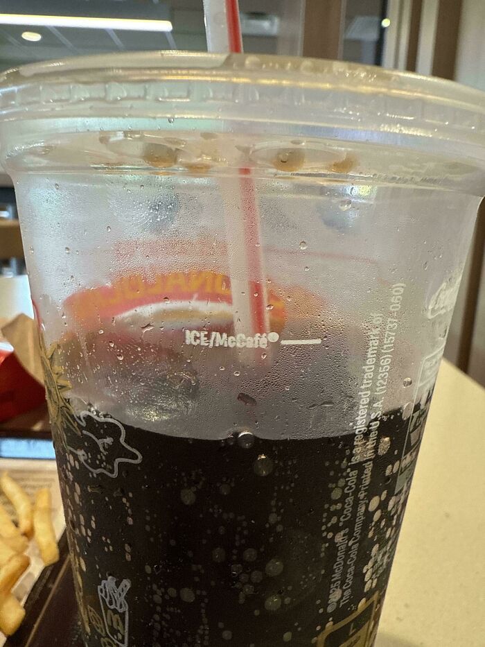 Close-up of a noticeably smaller soda cup with less beverage, illustrating obvious shrinkflation effects in America.