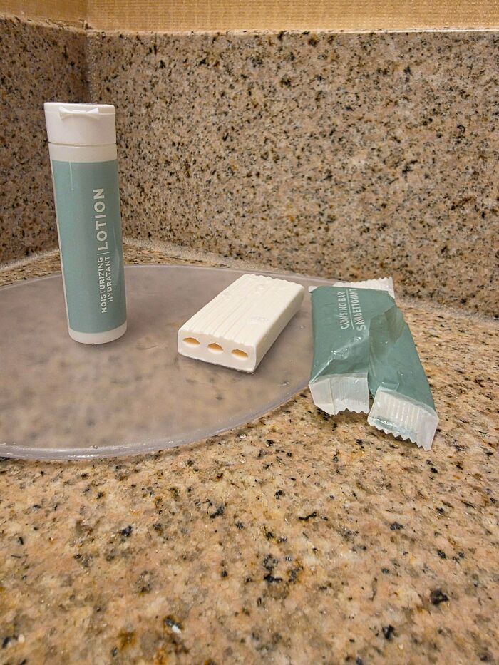 Moisturizing lotion and a smaller cucumber bar soap with three holes, illustrating obvious shrinkflation on a bathroom counter.