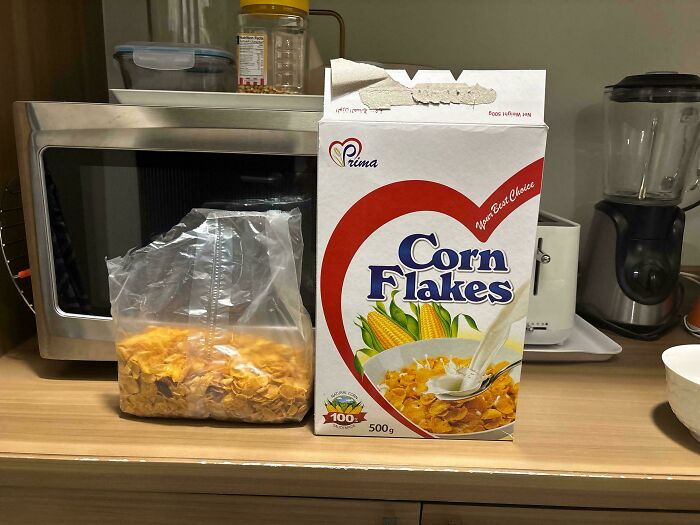 Box of corn flakes with a noticeably smaller inner bag illustrating obvious shrinkflation in American breakfast cereal packaging.