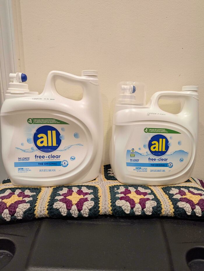 Two different sized all free clear detergent containers side by side showing obvious shrinkflation in packaging.