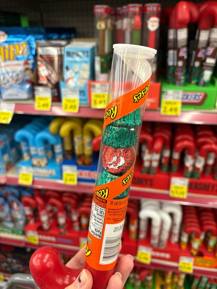 Clear plastic Reese's candy tube showing fewer chocolates inside, illustrating obvious shrinkflation on store shelf.