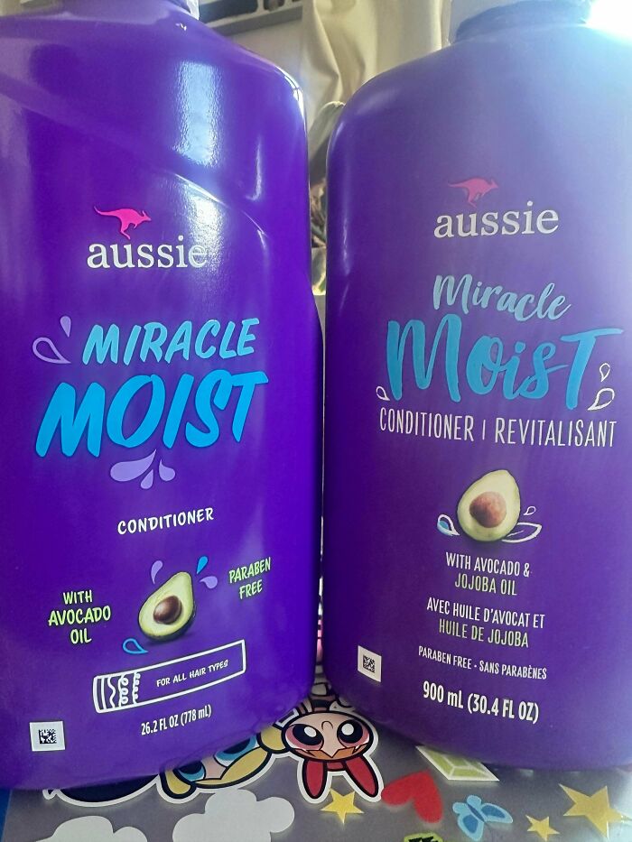 Two purple Aussie Miracle Moist conditioner bottles showing size shrinkflation with different volume amounts and avocado oil label.