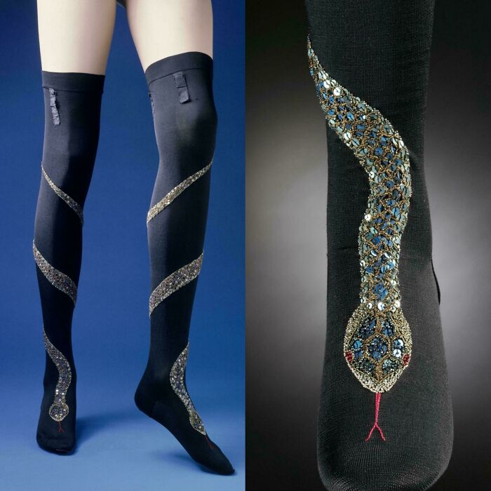 Black stockings with an ornate snake design made of beads and sequins, showcasing a unique historical garment style.