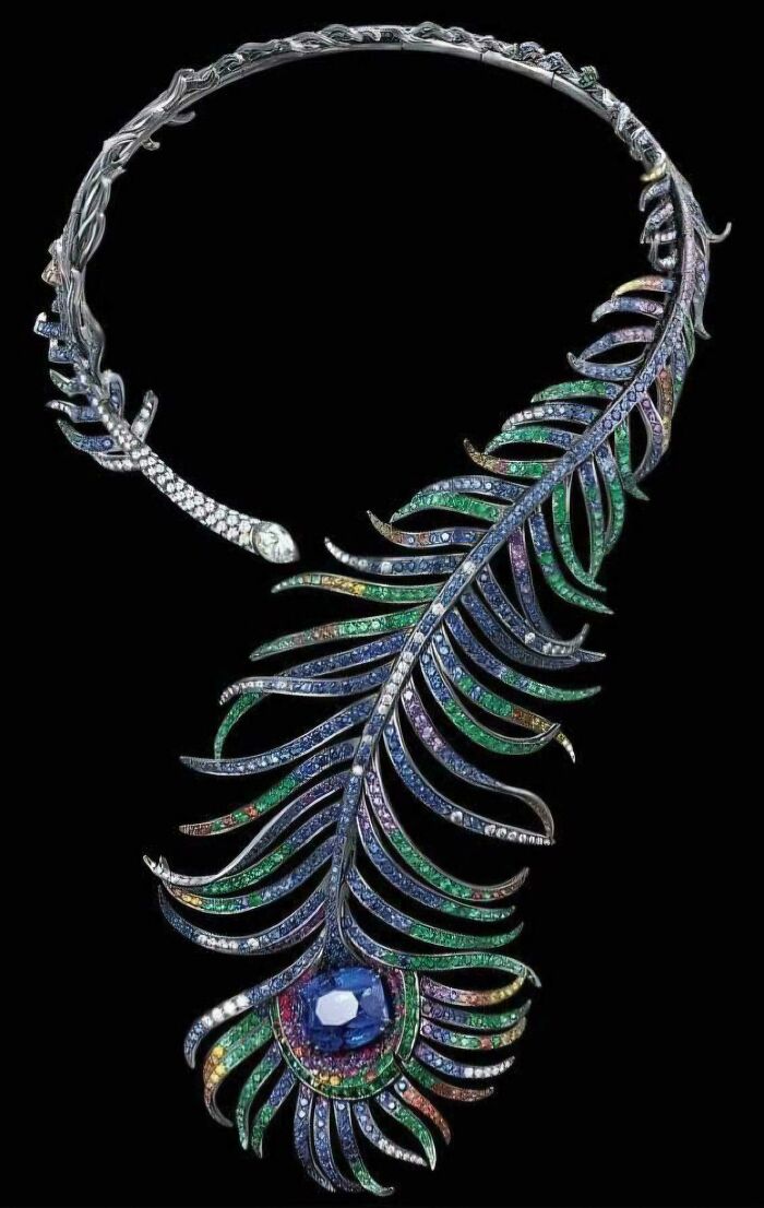 Intricate historical garment accessory featuring a jeweled peacock feather design with colorful gemstones and diamonds.