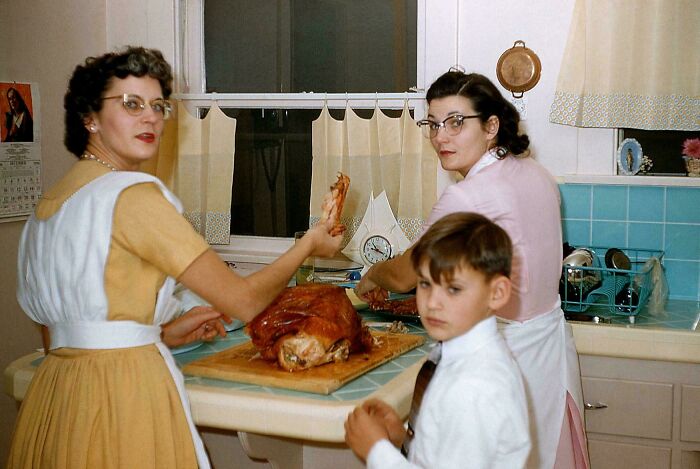 Vintage family preparing a turkey in a kitchen, a nostalgic photo reflecting moments from decades ago that still resonate today.