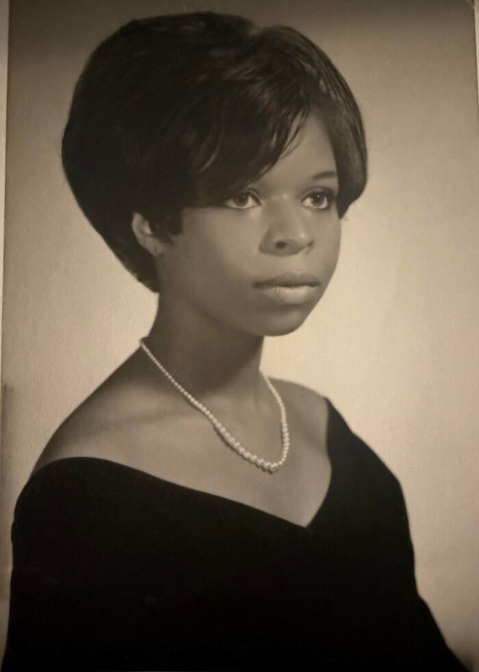Black and white vintage portrait of a young woman wearing a pearl necklace, evoking decades ago photos and timeless moments.