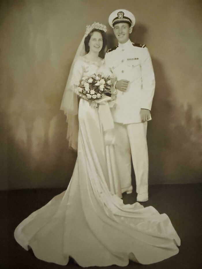 Vintage wedding photo of a bride in gown and groom in military uniform, a classic photo from decades ago.