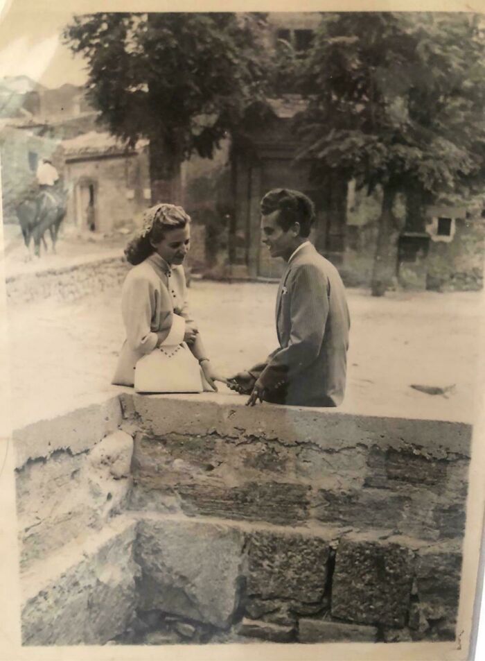 Vintage photo showing a man and woman engaged in conversation, capturing moments from decades ago with timeless charm.