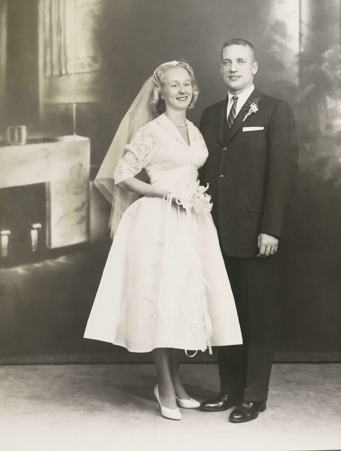 Vintage black and white wedding photo from decades ago showing a bride and groom in classic attire and pose.