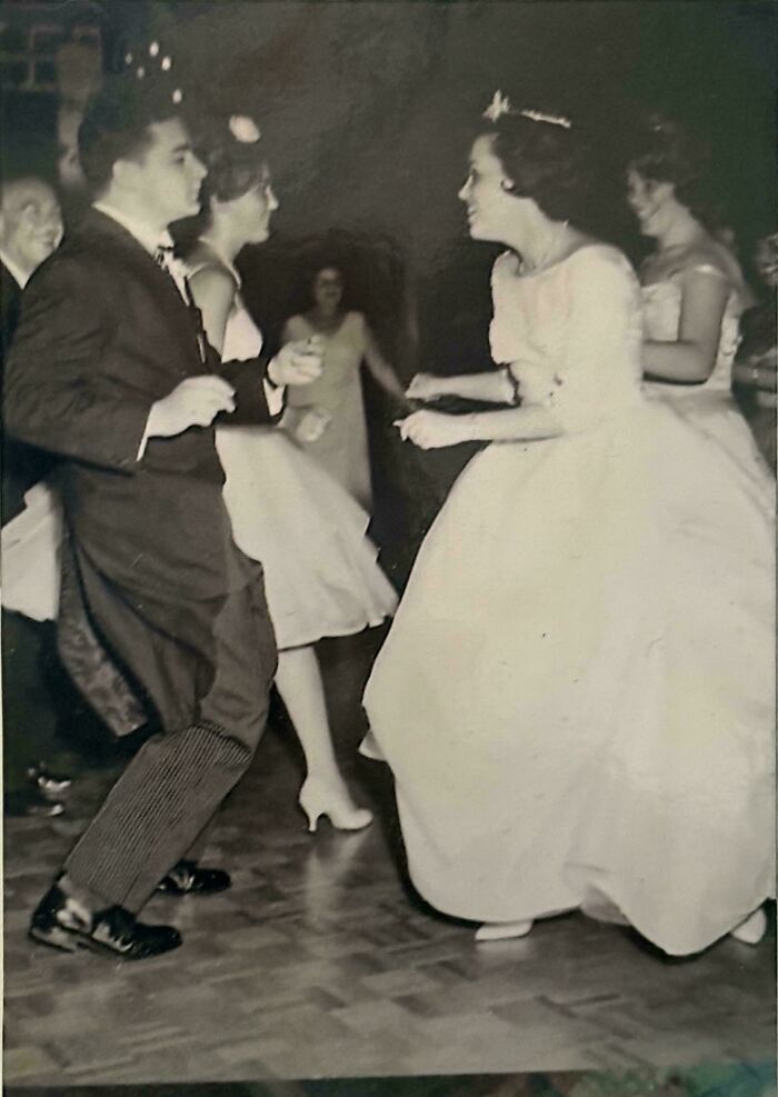 Vintage black and white photo of people dancing at a formal event, showcasing moments from decades ago.