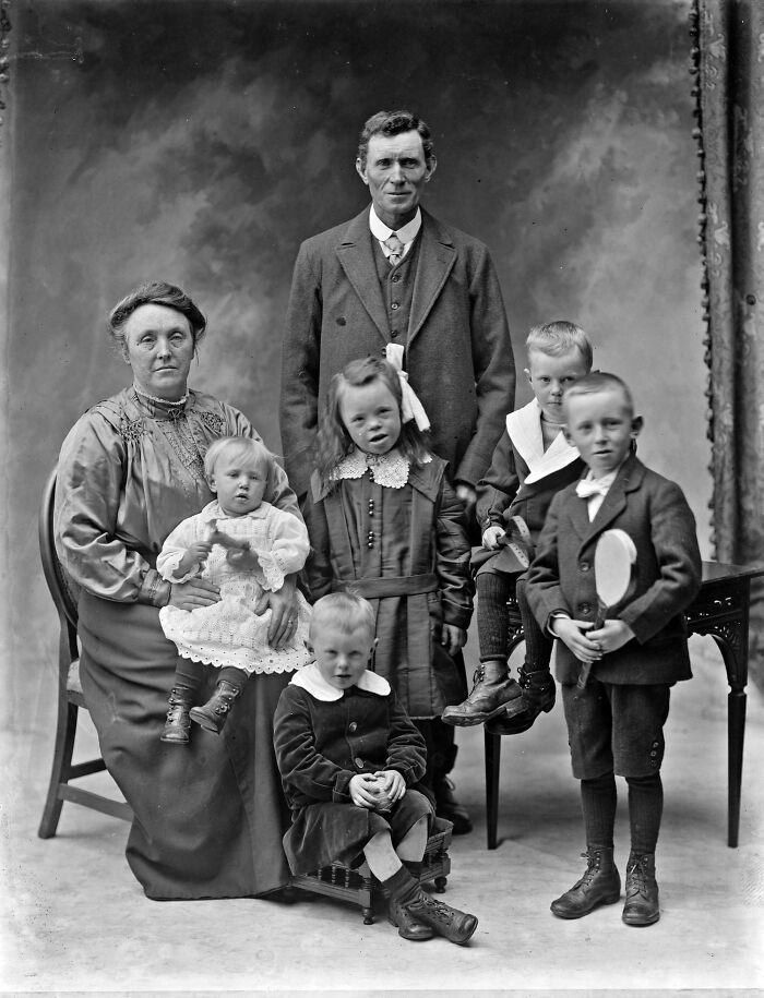 Vintage family portrait from decades ago showing parents and children in formal early 20th century attire, reflecting history.