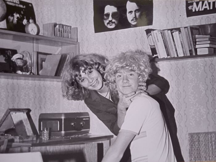 Black and white photo of two young people with curly hair in a vintage room, captured in 109 photos from decades ago.