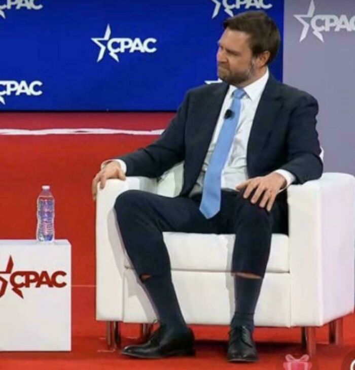 A cringey man at a CPAC event with ripped pants and socks, an example of how people can be awkward.