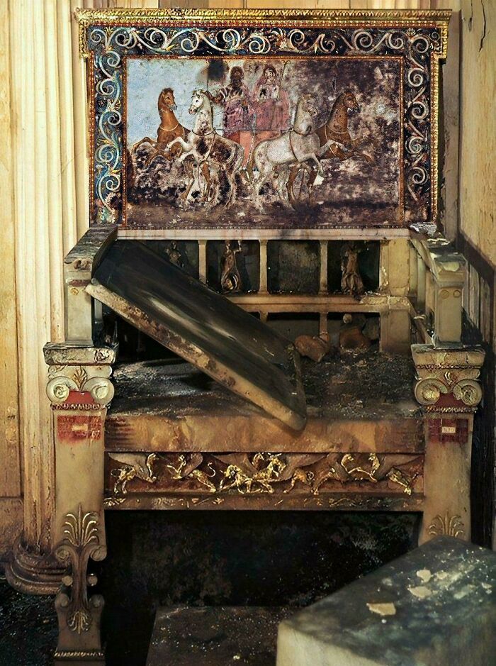 Ancient artifact featuring a detailed fresco of horses and riders on an ornate, weathered structure.