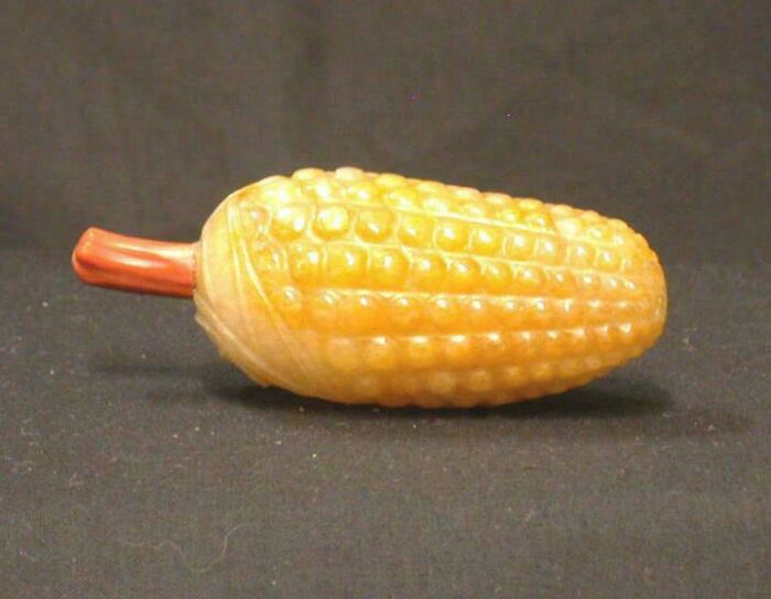 Small carved artefact shaped like an ear of corn, representing fascinating artefacts that survived to this day.