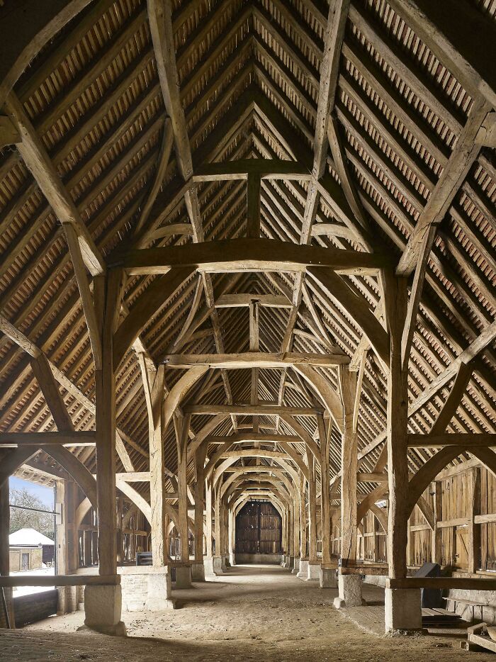 Interior of an ancient timber-framed barn showcasing historic artefacts that survived to this day, offering perspective on humanity.