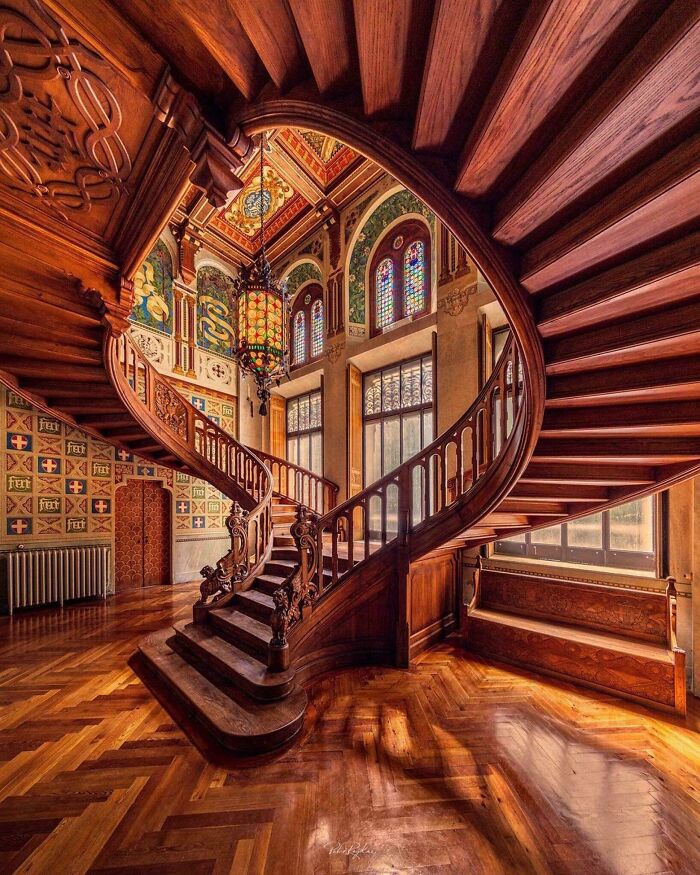 Intricately carved wooden staircase inside a historic building, showcasing artefacts that give perspective on the world and humanity.
