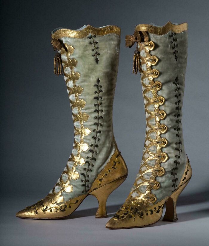 Pair of vintage high-heeled boots with gold embroidery, a fascinating artefact showcasing historical fashion craftsmanship.