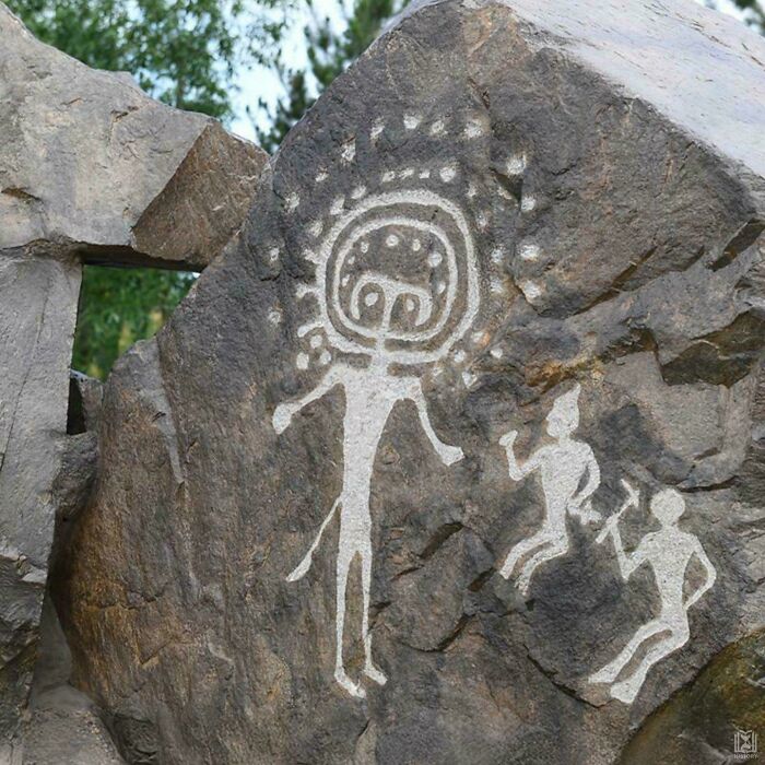 Ancient rock art depicting humanoid figures with unusual features, a strange earth mystery captured in stone.