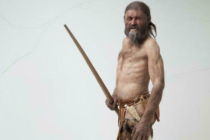 Reconstruction of prehistoric man holding a spear, showcasing strange Earth history and unbelievable human evolution facts.