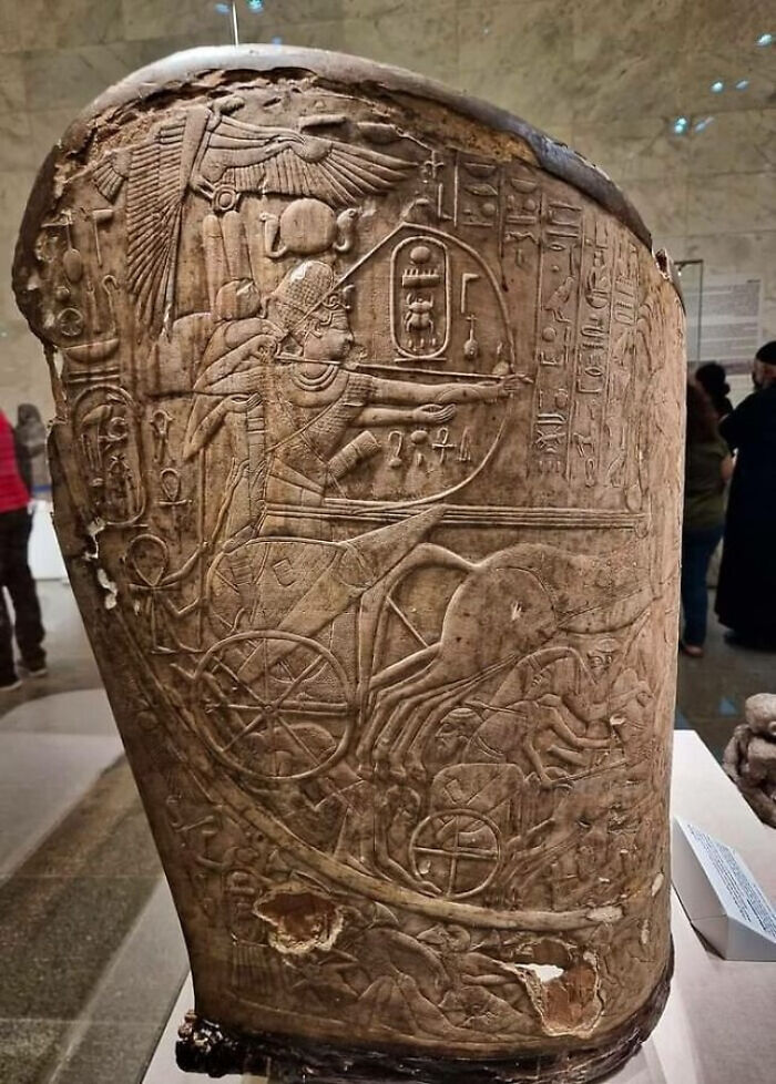 Ancient artifact with detailed carvings of a chariot and horses, showcasing strange earth historical artwork in a museum.