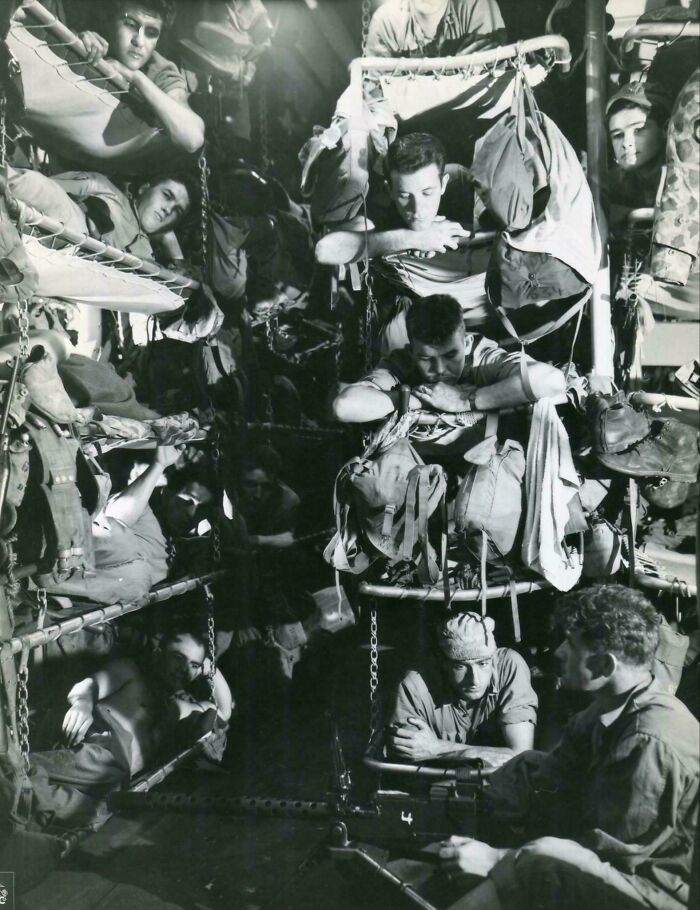 Soldiers resting on stacked bunks inside a military transport, illustrating a historical photo from a vastly different world.