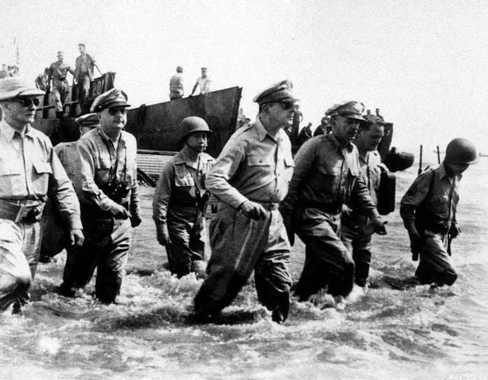 World War II soldiers wading through water from a landing craft in a historical photo representing a vastly different world.