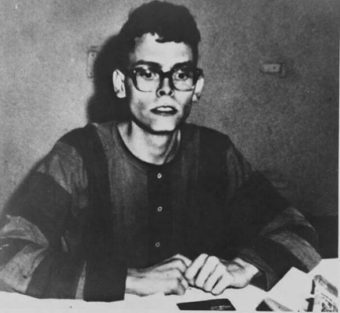 Black and white historical photo of a young man wearing glasses and striped clothing, representing a vastly different world.