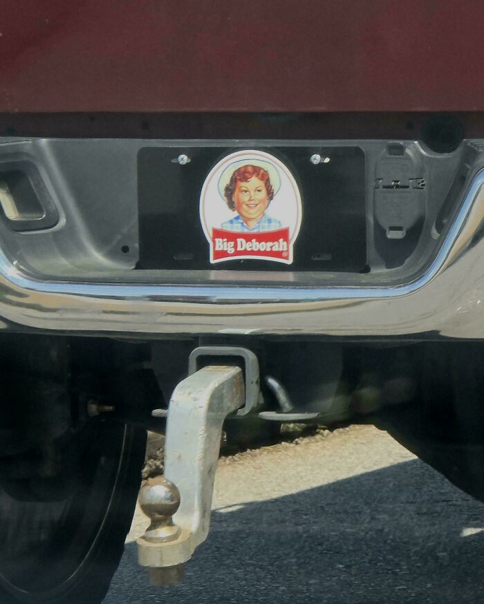 Rear bumper of a vehicle showing a humorous and unhinged bumper sticker with a vintage-style portrait and text saying Big Deborah.
