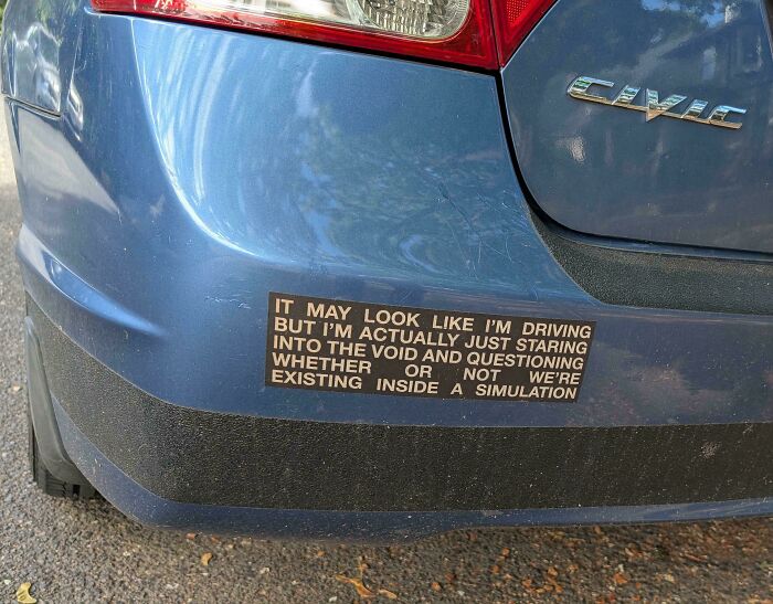 Blue Honda Civic with a hilarious and unhinged bumper sticker questioning existence inside a simulation.