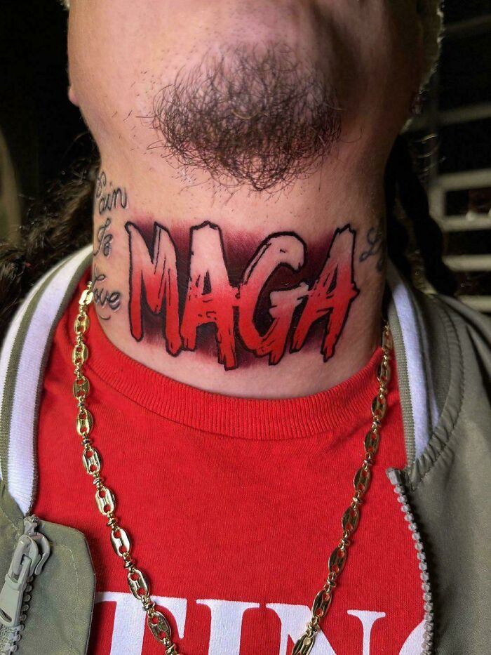 Neck tattoo with bold red and black letters spelling MAGA, surrounded by smaller script tattoos on the skin.
