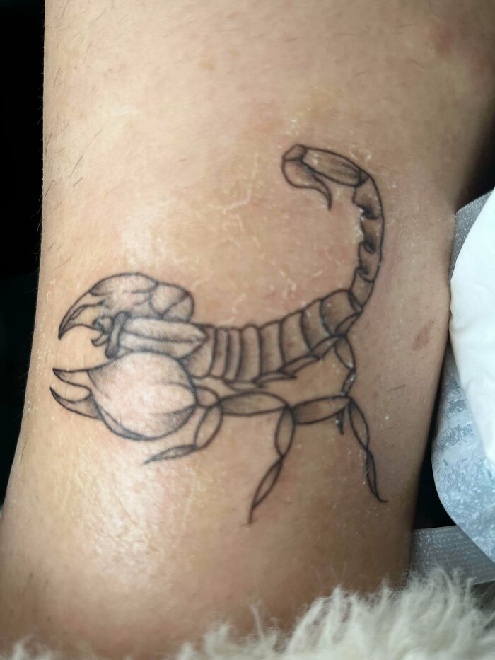 Outline tattoo of a scorpion on skin with uneven lines, showcasing one of the truly awful tattoos that are funny and tragic.