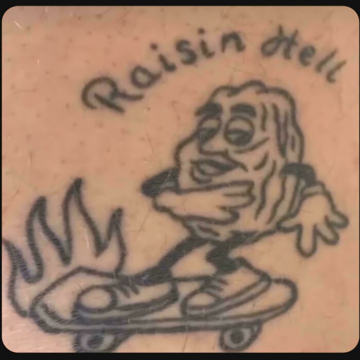 Black ink tattoo of a cartoon raisin character skateboarding with flames, a funny and awful permanent tattoo example.