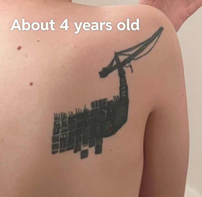 Awful tattoo of a poorly designed construction crane on a person's back, showcasing truly awful tattoos humor and tragedy.