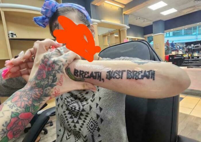 Arm tattoo with misspelled text showing a truly awful tattoo with funny and tragic elements in a tattoo parlor.