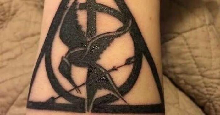 Black ink tattoo of a poorly executed symbol with abstract shapes, showcasing one of the truly awful tattoos.
