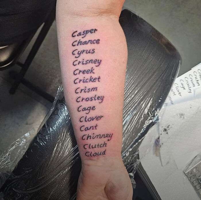 Forearm tattoo featuring a list of misspelled names in black ink, showcasing truly awful tattoos that are funny and tragic.