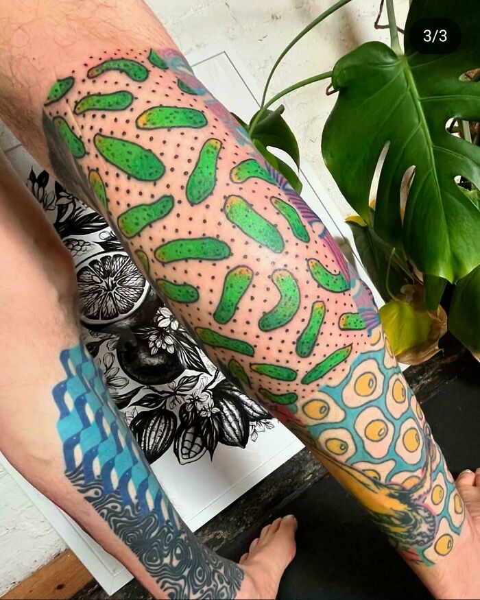 Leg tattoos featuring green pickle shapes and fried egg patterns, showcasing truly awful tattoos with humorous and tragic designs.