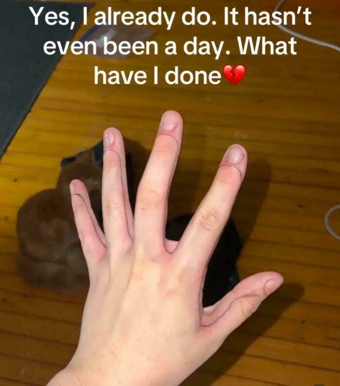 Hand with awkward finger tattoos outlined in black ink, showing a truly awful tattoo with funny and tragic results.