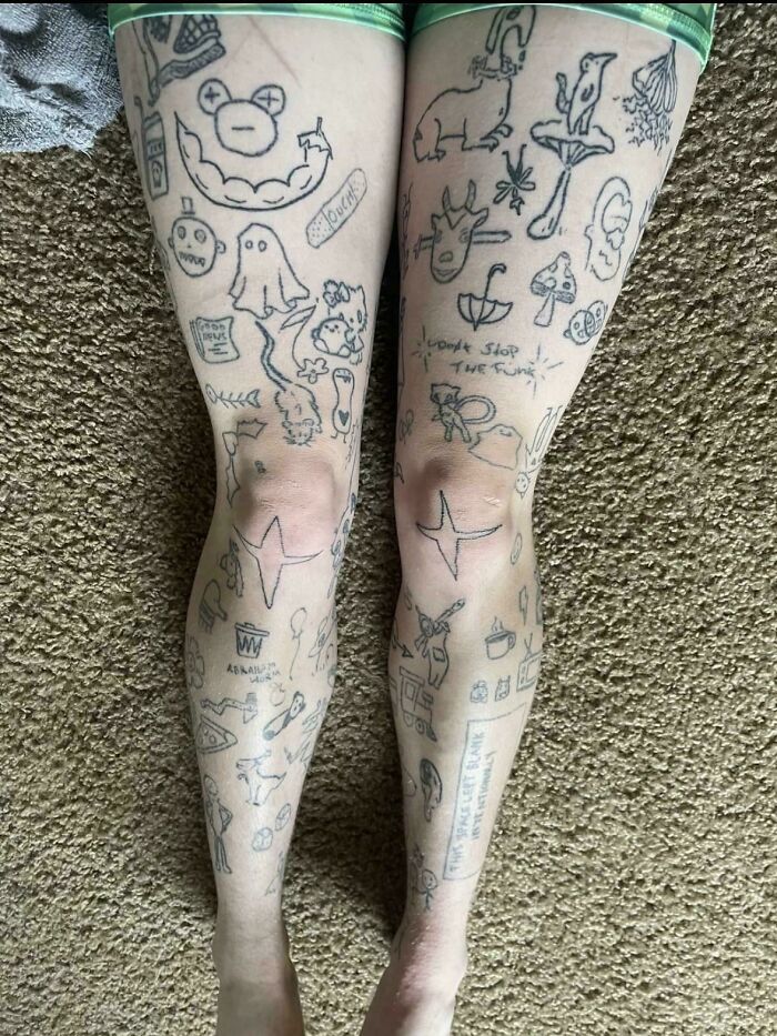 Legs covered with numerous simple line tattoos including animals, objects, and random doodles, showcasing truly awful tattoos.