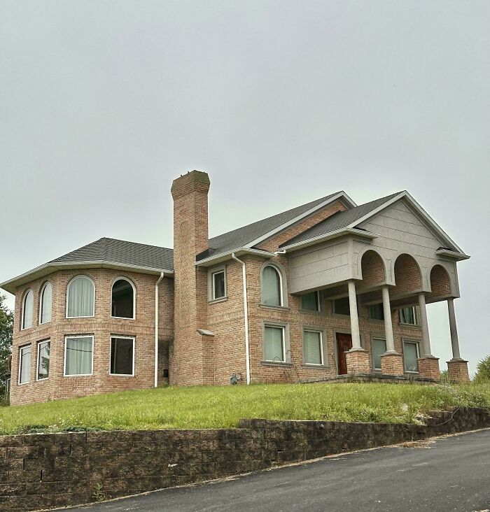 A large brick mansion with arched windows and a columned entrance, showing inspiration from Temu.