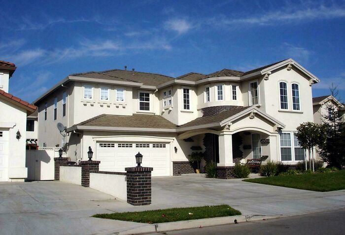 A large, modern mansion with a light exterior and multiple windows, highlighting elegant home inspiration.