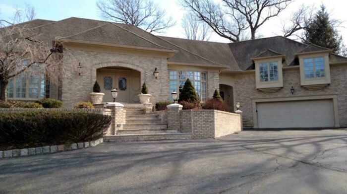 A large brick house with an attached garage and grand entrance. Many people aspire to mansions, creating a Temu version.