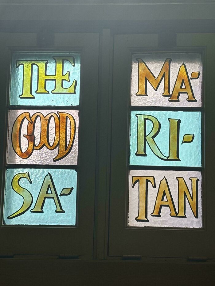 A hilariously confusing message in stained glass reads 'THE GOOD SA' and 'MA RI TAN', forming 'The Good Samaritan'.