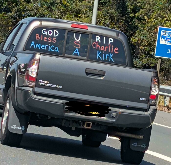The back of a pickup truck with a confusing message written on the windows, an example of poor sign design.