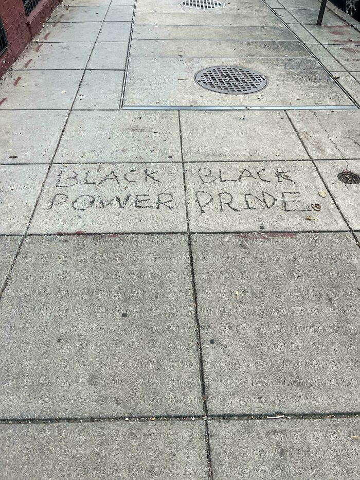 Black Power and Black Pride written on separate sidewalk slabs, creating a subtly confusing message with poor sign design.