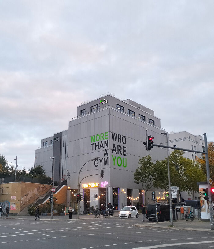 An external view of a gym building with a poor sign design that reads MORE WHO THAN ARE A GYM YOU, creating a confusing message.