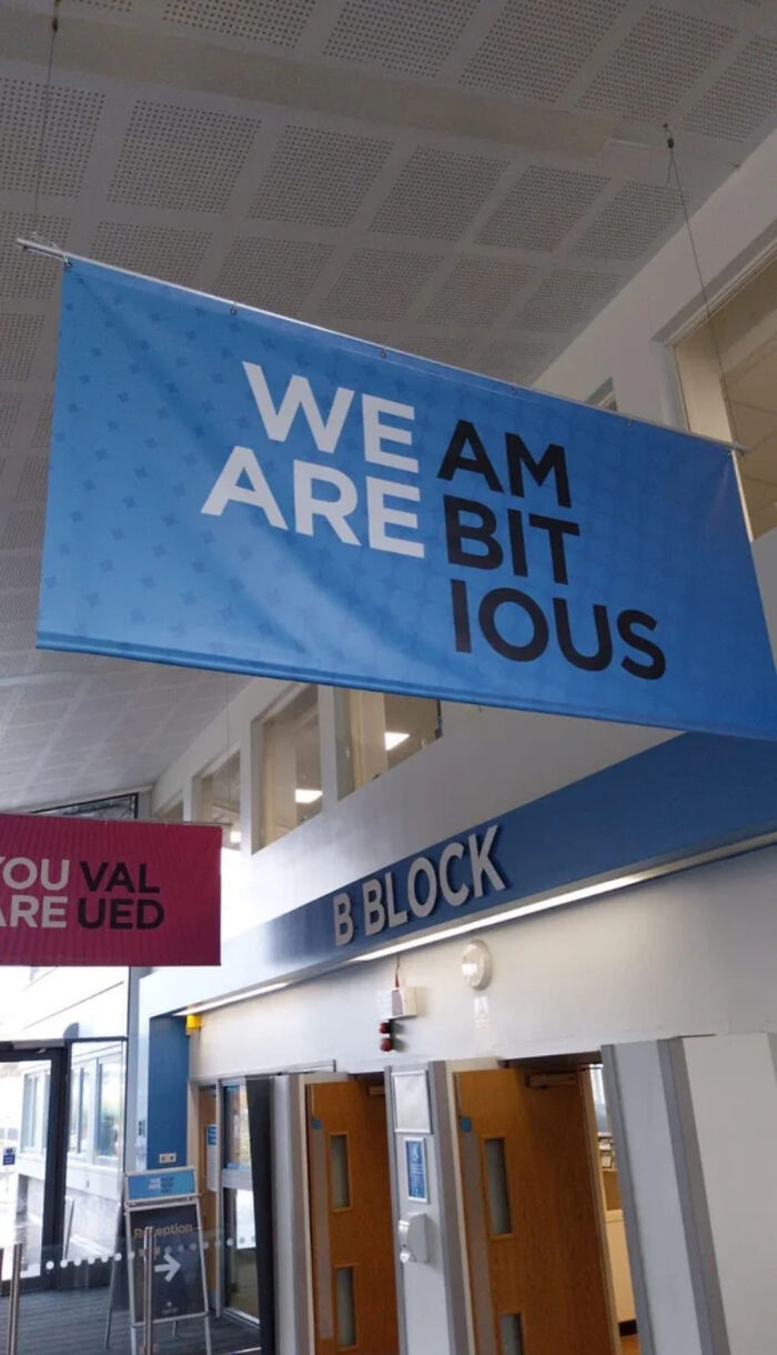A blue banner with a hilariously confusing message that reads We Am Are Bit Ious, a prime example of poor sign design.